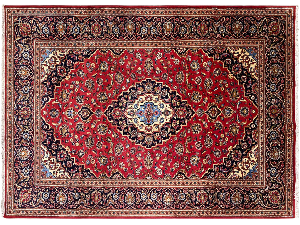 Orientteppich mit rotem Feld, mittiger blau-weißer Rosette und detailreicher Zierbordüre