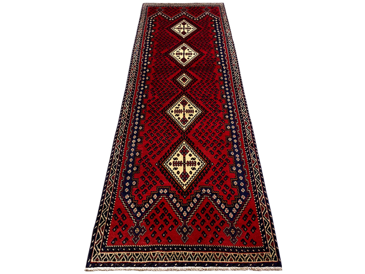 Red runner rug with a tapered look, diamond motifs in cream