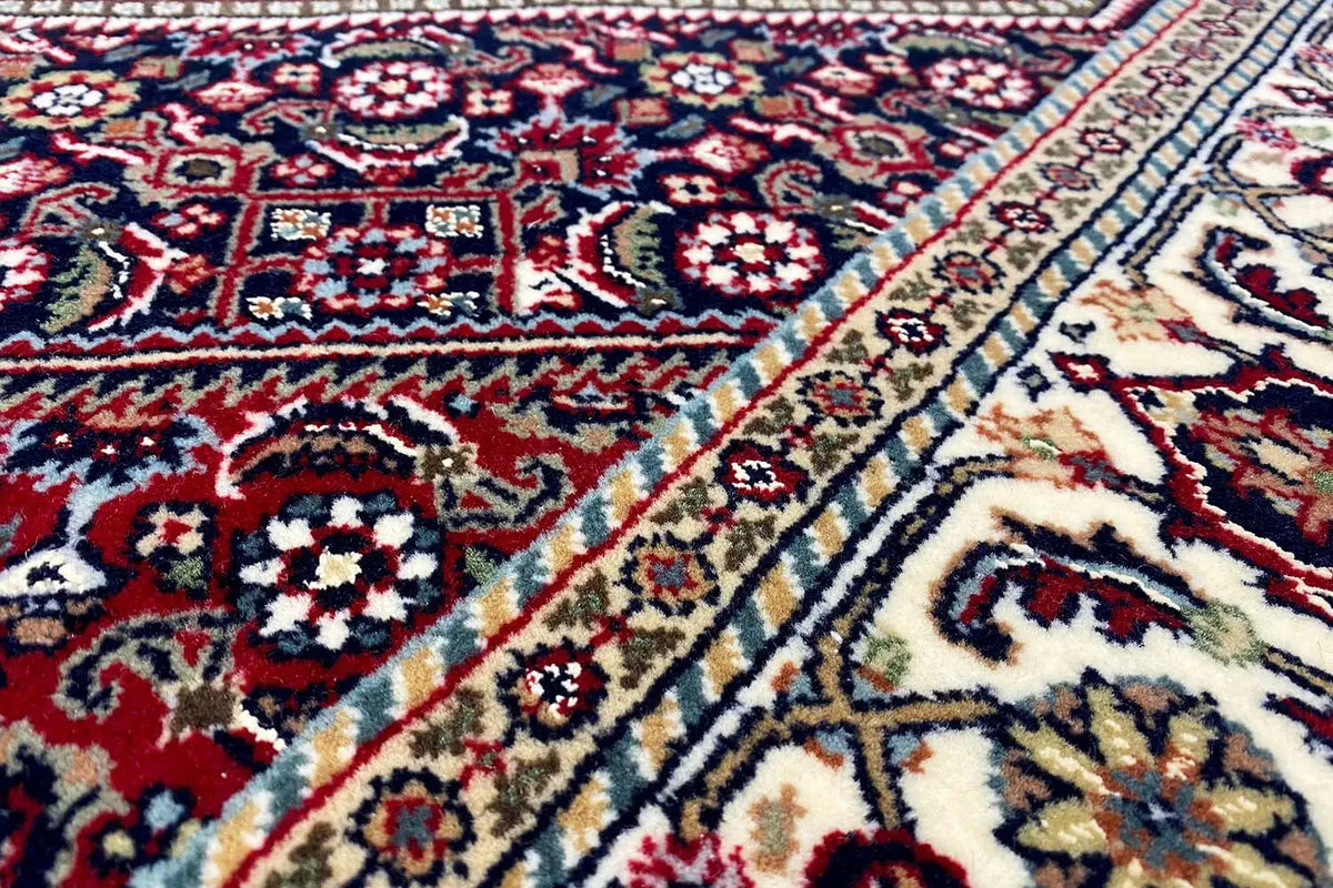 Oriental Bidjar rug, close-up: blue-red ornamental fields with cream-colored decorative borders