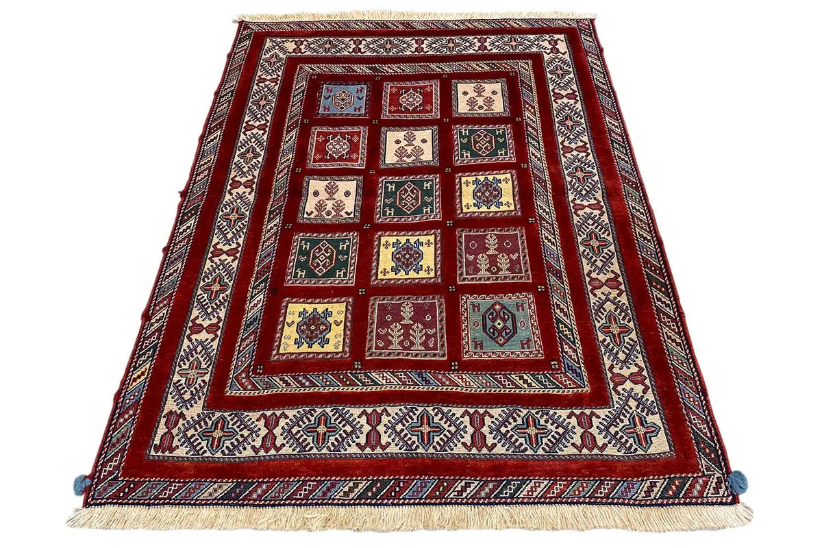 Oriental rug with a red central pattern, a surrounding border, and fringes at the corners