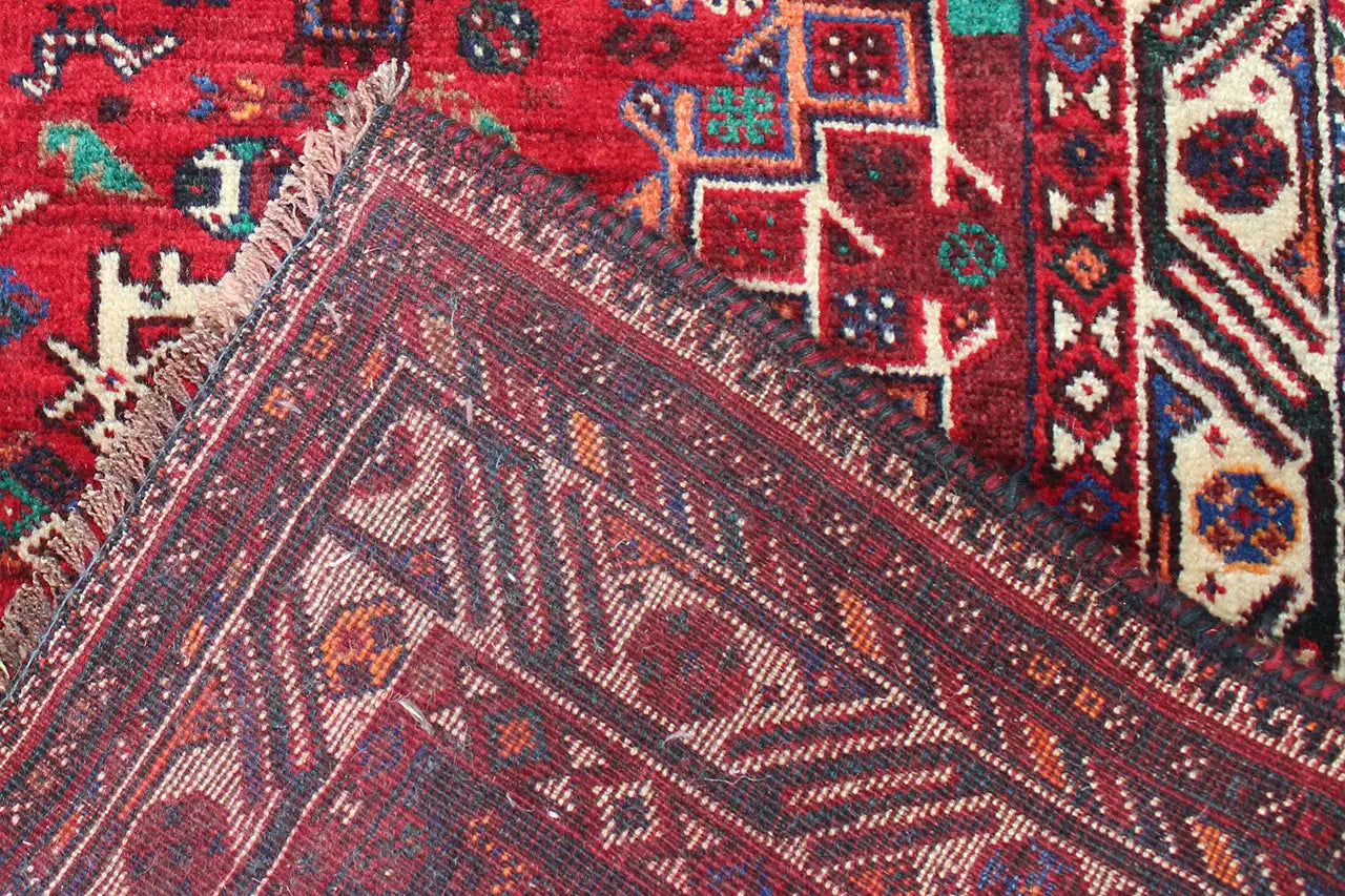 Close-up of the carpet weave: red surface with geometric patterns and lines