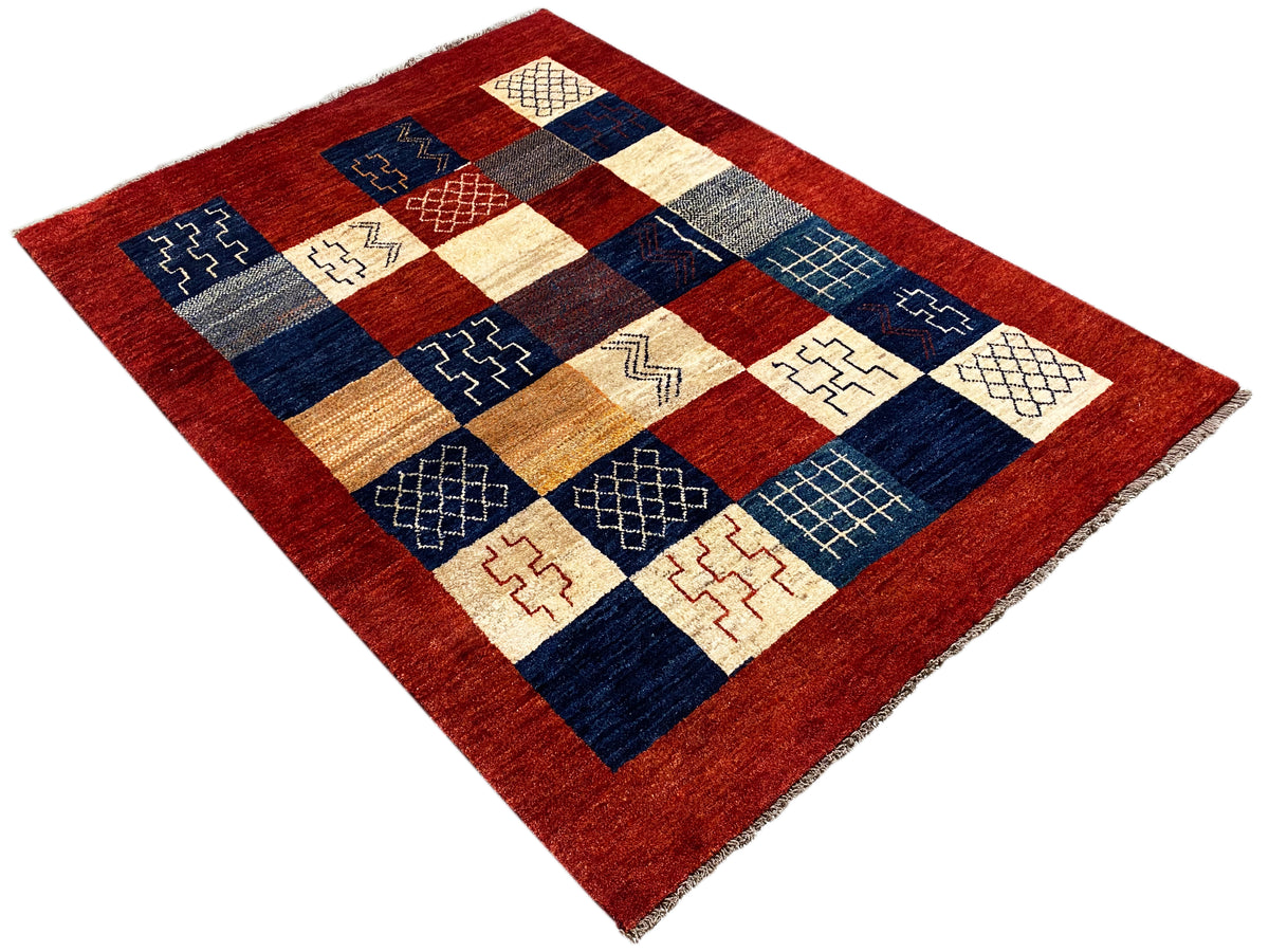Gabbeh-Teppich (194x140 cm) schräg: roter Rand, Patchwork-Design in Blau und Beige