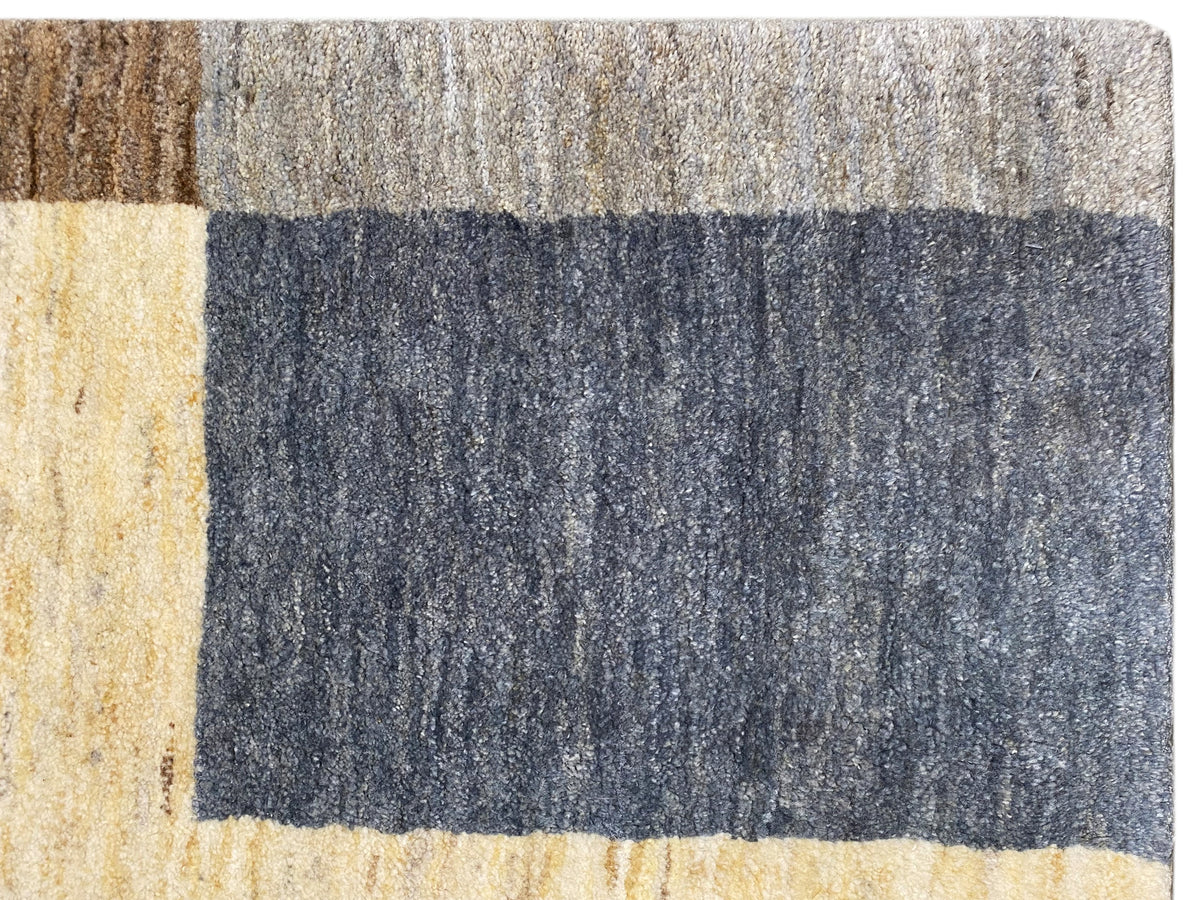 Detailaufnahme des Gabbeh-Teppichs: strukturierter Flor mit blauen und beigen Quadraten