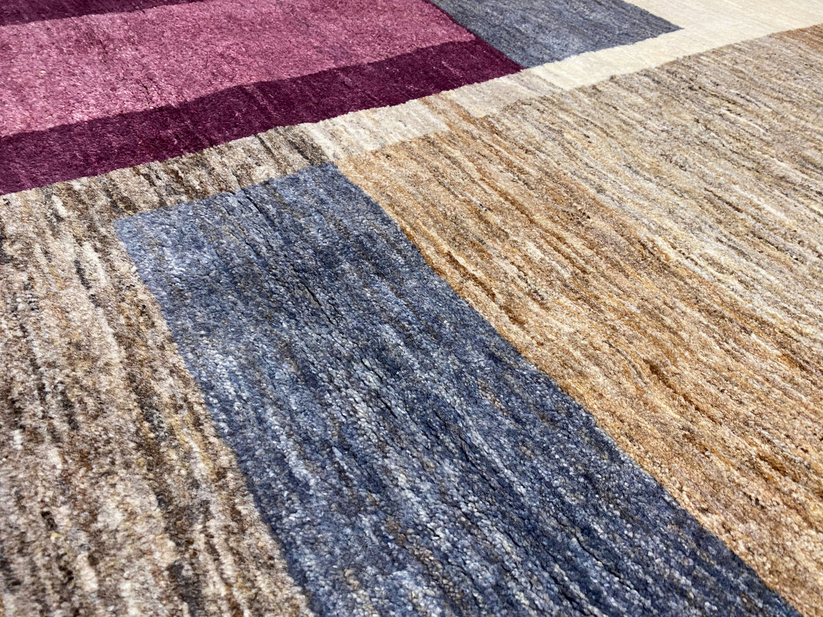 Nahaufnahme Gabbeh-Teppich mit blauen und beigen Streifen, Akzenten in Bordeaux
