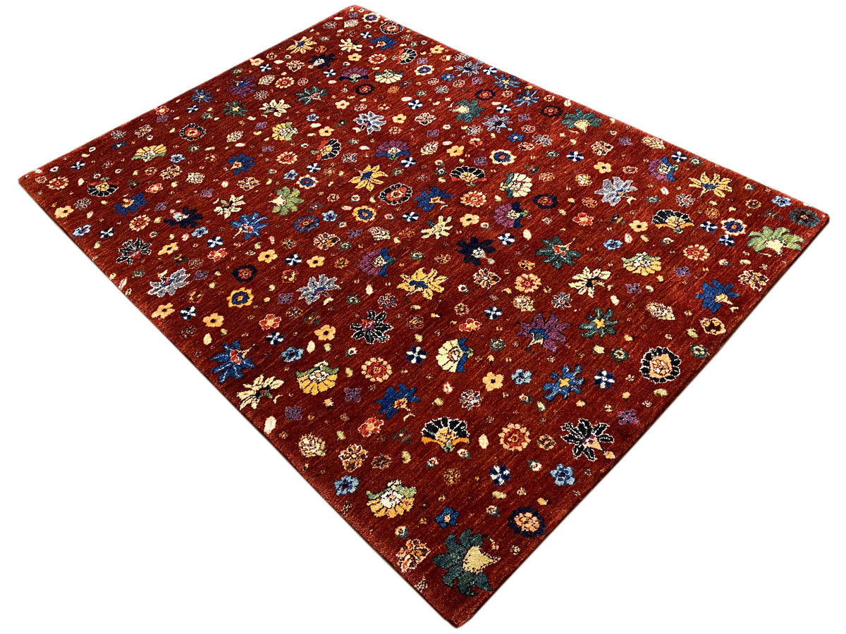 Teppich in quadratischer Perspektive: rötlich-brauner Hintergrund mit mehrfarbigen Blumen.