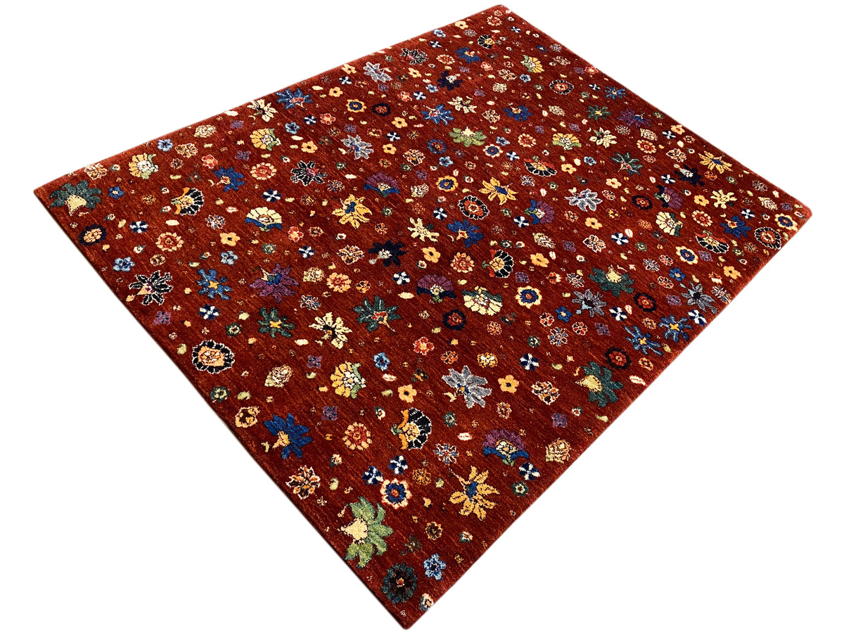 Teppich mit rötlich-braunem Untergrund und buntem Blumenornament, diagonale Ansicht.