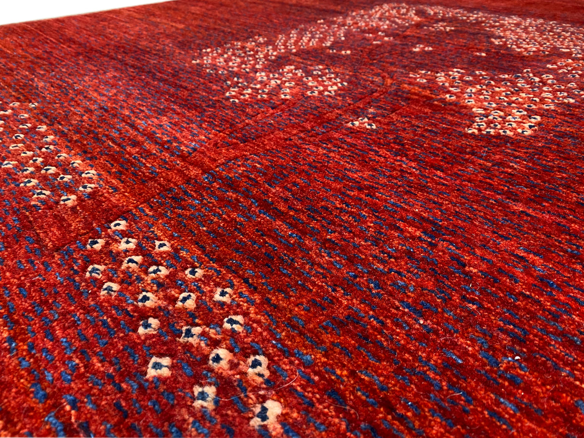 Red carpet detail with border arrangement and medallion pattern in a pointillist design