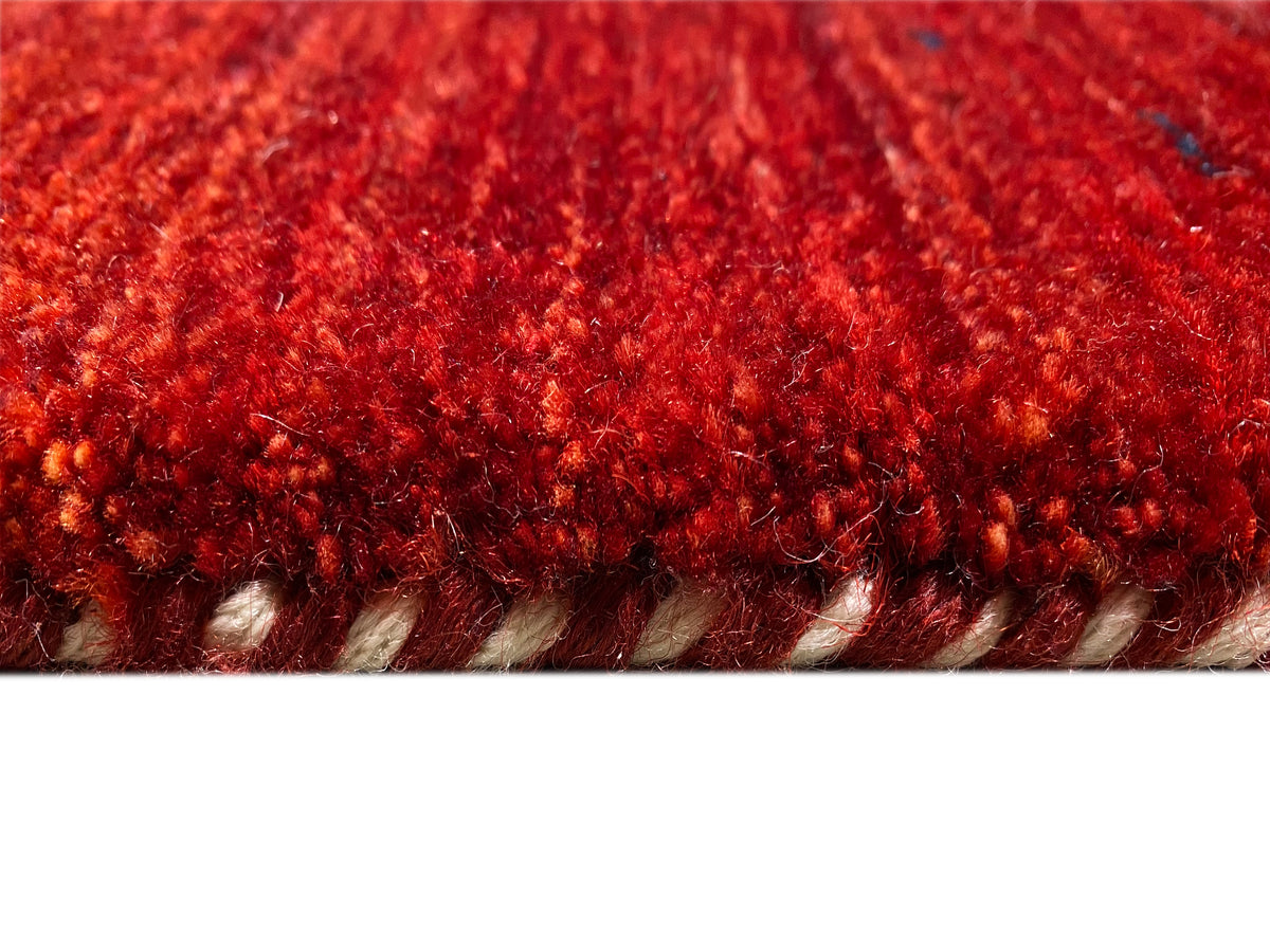Red carpet close-up of the edge with dense pile and visible hem