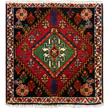 Poshti rug, square: black woven rug with red, green, and blue decorative pattern
