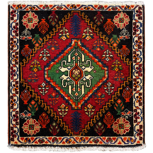 Poshti rug, square: black woven rug with red, green, and blue decorative pattern