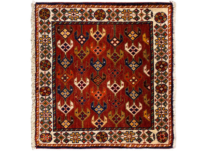 Square rug 61x61 cm with a red patterned field, ornamental border, and fringes