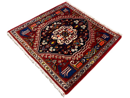 Rug with a red border and dark blue center, star-shaped ornament, fringe