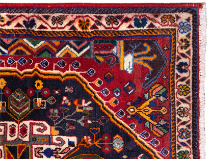 Carpet edge with decorative border, red-and-blue pattern, and white fringes, close-up view