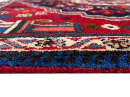 Rug edge with short pile, red lower edge, and blue-and-white pattern