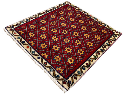 Square rug diagonally patterned with a red background and multicolored star squares
