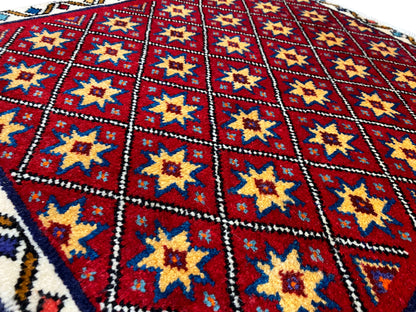 Close-up of the carpet: red diamond pattern with yellow and blue stars
